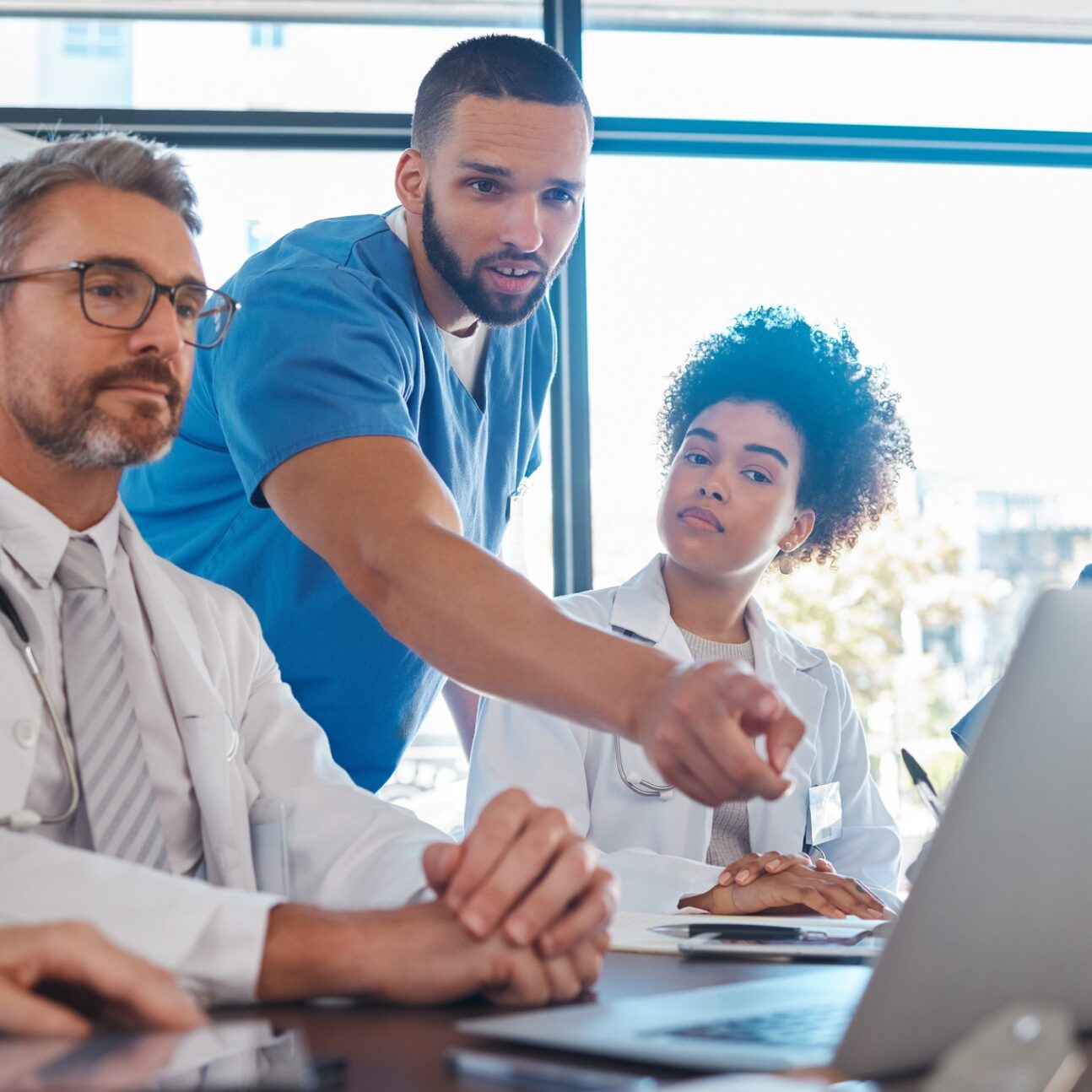 Medical, meeting and laptop for team in office in discussion, brainstorming and planning. Doctor, nurse and computer on desk show diversity in collaboration, teamwork or workshop for data analytics.